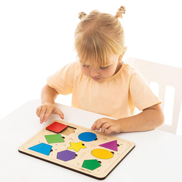 Child playing with a colorful wooden shape puzzle 