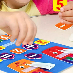 Close-up of movable number tiles and +, = symbols on the Montessori felt math board for addition practice.
